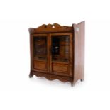 LATE VICTORIAN SMOKER'S OAK CABINET with a pair of glazed doors opening to reveal small drawers