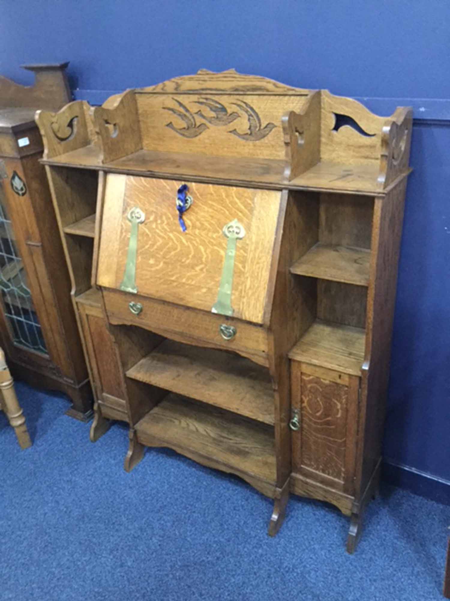 ARTS & CRAFTS OAK ESCRITOIRE BOOKCASE OF LIBERTY DESIGN the raised back carved with three flying