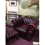 OXBLOOD ARMCHAIR IN THE CHESTERFIELD MANNER with raised buttonback and arms, studded details,