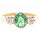 EMERALD AND DIAMOND THREE STONE RING set with a central oval emerald 7.