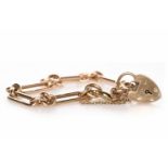 NINE CARAT GOLD BRACELET formed by oval and oblong links, with a heart shaped padlock clasp,