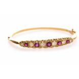 EIGHTEEN CARAT GOLD RUBY AND DIAMOND BANGLE set with five round brilliant cut diamonds totalling