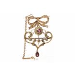 EDWARDIAN NINE CARAT GOLD BROOCH PENDANT of openwork form and set with seed pearls and two garnets,