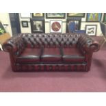 THREE SEAT BUTTON BACK CHESTERFIELD STYLE SOFA upholstered in ox blood red leather,