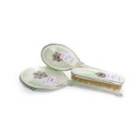 ENAMEL BACKED THREE PIECE DRESSING TABLE SET the centre decorated with a floral spray,