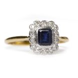 SAPPHIRE AND DIAMOND CLUSTER RING the central emerald cut sapphire surrounded by collet set round