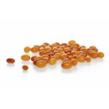 GROUP OF CERTIFICATED EARLY TWENTIETH CENTURY BUTTERSCOTCH AMBER BEADS of ovoid form,