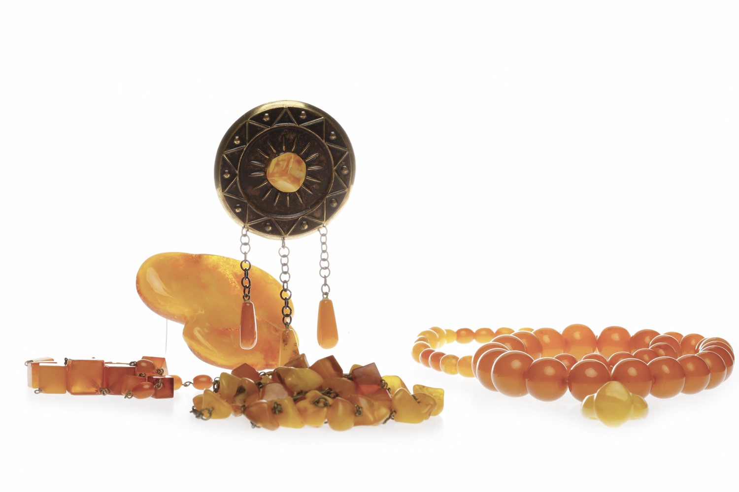 LARGE AMBER BROOCH of irregular form, 62x52mm long, 20.5g; along with a carved amber ring, 1.3g;