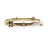 TEN CARAT GOLD BUCKLE MOTIF BANGLE with safety chain, 9.