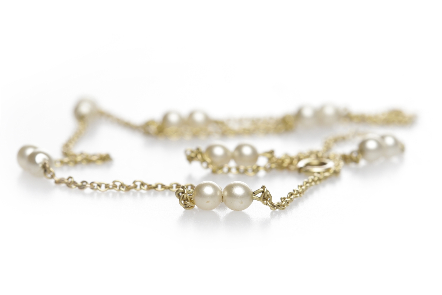 PEARL AND NINE CARAT GOLD CHAIN NECKLACE formed by sections of chain set with pairs of pearls each