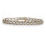 NINE CARAT GOLD DIAMOND SET BRACELET formed by S shaped links separated by alternating diamond set