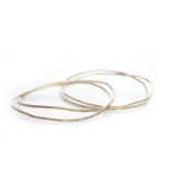 FOUR GOLD BANGLES each of irregular form, unmarked but test as 14-24 carat gold,