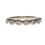 DIAMOND SEVEN STONE RING with collet set round brilliant cut diamonds totalling approximately 0.