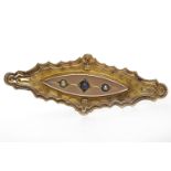 VICTORIAN NINE CARAT GOLD BROOCH of elliptical form, with a central sapphire and pearl set plaque,