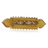 VICTORIAN FIFTEEN CARAT GOLD RUBY AND PEARL BROOCH set with three rubies and two split pearls,