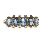 GOLD PLATED BLUE GEM SET RING the five oval cut gems with the largest measuring approximately 5.