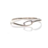 SILVER DIAMOND SET BANGLE of oval form and with a single round brilliant cut diamond of