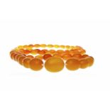 BUTTERSCOTCH AMBER NECKLACE formed by ovoid beads, the largest bead approximately 21mm long,