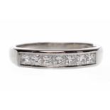 EIGHTEEN CARAT WHITE GOLD DIAMOND SET BAND with seven channel set princess cut diamonds totalling