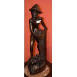 A BALINESE CARVED HARDWOOD FIGURE, modelled with a fisherman holding a net, 23.5'' (60cm) high. (1)