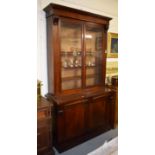 A VICTORIAN MAHOGANY BOOKCASE, the moulded pediment above two glazed doors, the base possibly