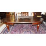 A VICTORIAN MAHOGANY DINING TABLE, the moulded top with D shaped ends and two spare leaves, raised