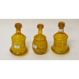 A GARNITURE OF THREE AMBER GLASS DECANTERS AND STOPPERS