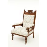 AN EDWARDIAN CARVED WALNUT ARMCHAIR OR LIBRARY CHAIR