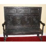 A CARVED OAK HIGH-BACK BENCH