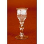 AN 18TH CENTURY ENGRAVED ARMORIAL CORDIAL GLASS