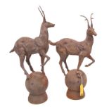 A PAIR OF HEAVY CAST IRON STAG-ON-BALL PILLAR FINIALS