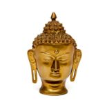 AN EMBOSSED BRASS MODEL OF A BUDDHA HEAD, probably Thai, 10" (26cm) high. (1)