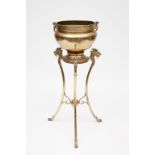 AN UNUSUAL BRASS JARDINIERE AND STAND, the jardiniere with two brass ring handles, on a stand with