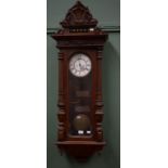 A WALNUT-CASED VIENNA WALL CLOCK, with shell crest above a circular two-stage enamel dial, with