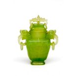 A CHINESE CARVED JADEITE VASE AND COVER, with elephant mask and ring handles, 7.5" (19cm). (1)