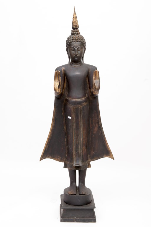 A CARVED, EBONISED AND PARCEL GILT FIGURE OF A BUDDHA, with flowing gown and hands facing forward,