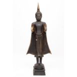 A CARVED, EBONISED AND PARCEL GILT FIGURE OF A BUDDHA, with flowing gown and hands facing forward,