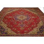 A LARGE BURGUNDY GROUND TABRIZ CARPET, with centre medallion and all-over stylised floral field,