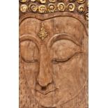 A LARGE CARVED SOUTHEAST ASIAN PANEL, depicting a Buddha mask in relief, 42" (107cm) high x 28" (