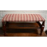 AN OBLONG OAK FOOT STOOL, the top covered in candy stripe fabric, on four turned legs, united by a