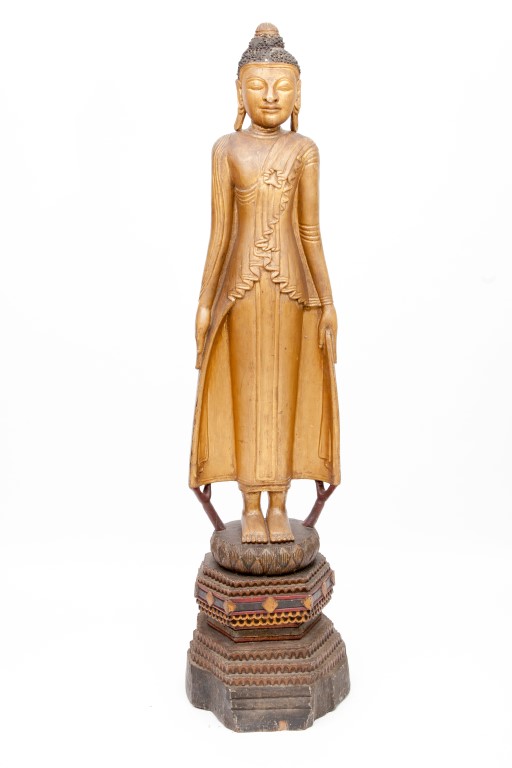 A TALL CARVED GILTWOOD AND EBONISED FIGURE OF A BUDDHA, wearing a long gown, on octagonal shaped and