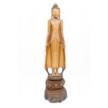 A TALL CARVED GILTWOOD AND EBONISED FIGURE OF A BUDDHA, wearing a long gown, on octagonal shaped and