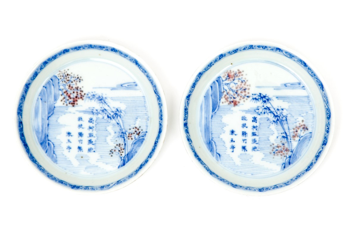 A PAIR OF VERY SMALL CIRCULAR BLUE, WHITE, AND BROWN DISHES, each decorated with a landscape, the