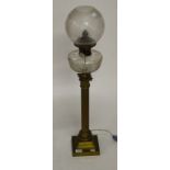 A HEAVY BRASS OIL LAMP, with cut glass reservoir and frosted glass shade, on a reeded stem with