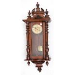 A SMALL WALNUT CASED VIENNA WALL CLOCK, with circular dial and Arabic numerals, with brass pendulum,