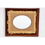 A LATE 19TH CENTURY AND EARLY 20TH CENTURY GILT MIRROR FRAME, with oval plate, the frame with leaf