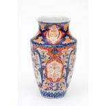 A JAPANESE IMARI PORCELAIN VASE, of baluster reeded form, decorated in typical palette, with