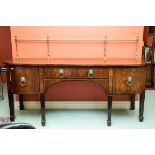 A MAHOGANY BOW FRONTED SIDE BOARD, early 19th century, with brass rail and centre frieze drawer,