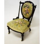 A LATE VICTORIAN EBONISED OCCASIONAL CHAIR, the oval padded back above serpentine-fronted padded