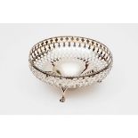 A PIERCED SILVER BASKET BOWL, Birmingham 1923, with leaf cast edge and raised on three paw feet,